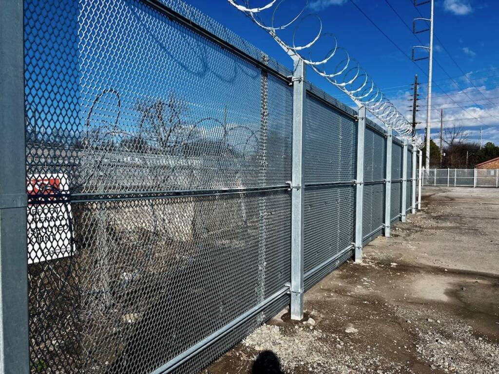 Chain link fence with barbed-wire on top.