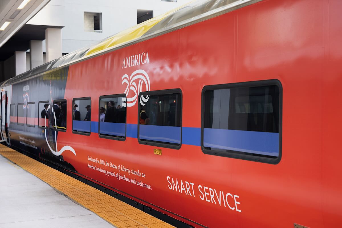 Predominantly red passenger car with text about Statue of Liberty