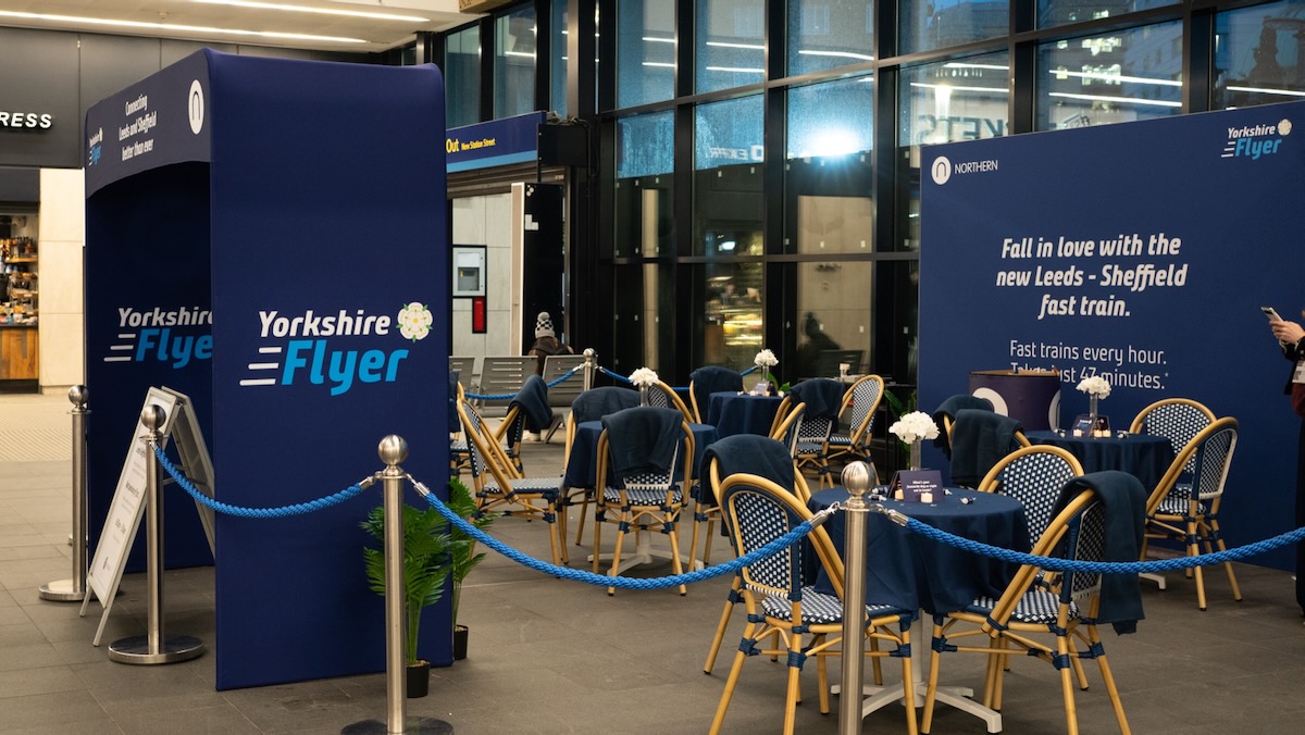 Tables and chairs in area at railroad station with "Yorkshire Flyer" signate