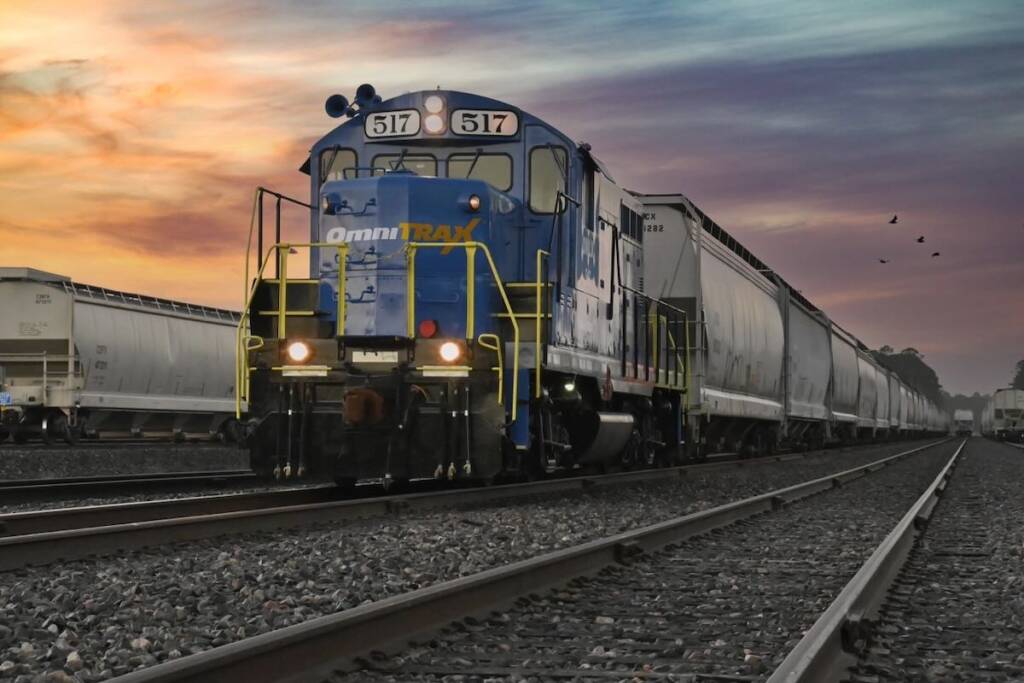 Locomotive switching hopper cars at sunset
